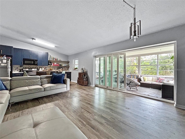 1609 Haven Bnd, Tampa, FL 33613 - living room with lofted ceiling, wood finished floors, and a textured ceiling