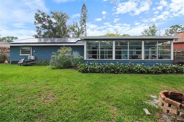 1609 Haven Bnd, Tampa, FL 33613 - rear view of house featuring a yard, a sunroom, and roof mounted solar panels