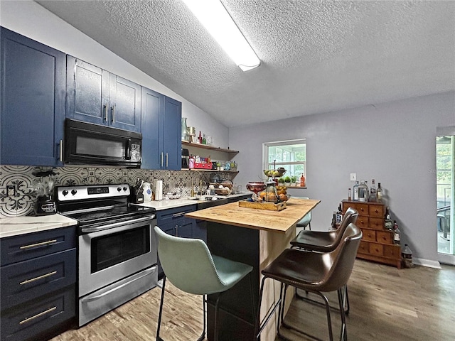 1609 Haven Bnd, Tampa, FL 33613 - kitchen featuring black microwave, stainless steel electric range, blue cabinetry, a textured ceiling, and a breakfast bar