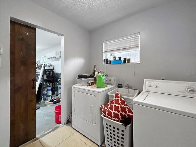 1609 Haven Bnd, Tampa, FL 33613 - laundry area featuring washer and dryer, a wall mounted air conditioner, a textured ceiling, and light tile patterned flooring