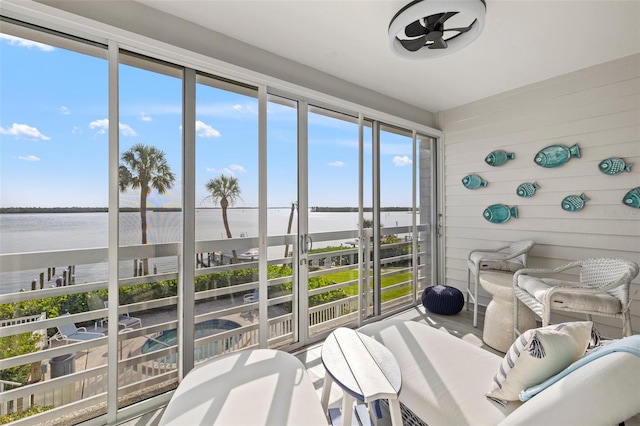 615 Dream Island Pl Unit 210, Longboat Key, FL 34228 - sunroom / solarium with a water view, a ceiling fan, and wood walls