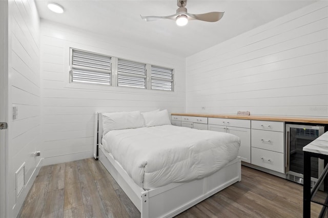 615 Dream Island Pl Unit 210, Longboat Key, FL 34228 - bedroom with wine cooler, wood finished floors, wooden walls, and a ceiling fan