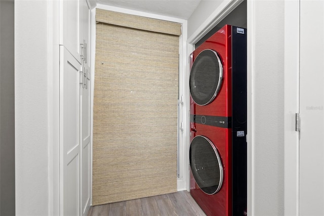 615 Dream Island Pl Unit 210, Longboat Key, FL 34228 - washroom featuring stacked washer / drying machine and wood finished floors
