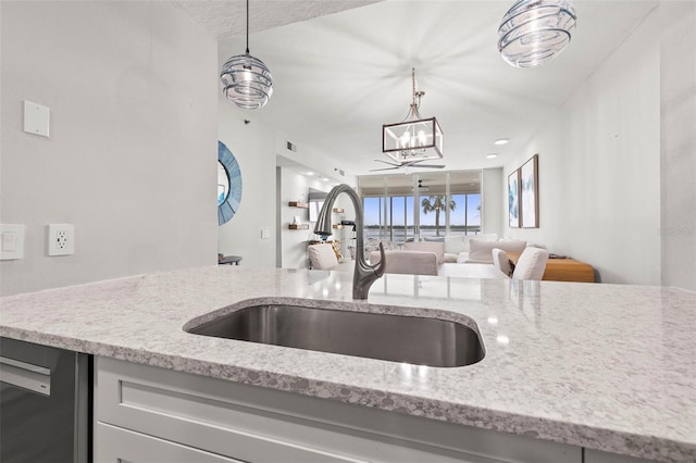 615 Dream Island Pl Unit 210, Longboat Key, FL 34228 - kitchen featuring light stone countertops, dishwasher, a chandelier, hanging light fixtures, and open floor plan