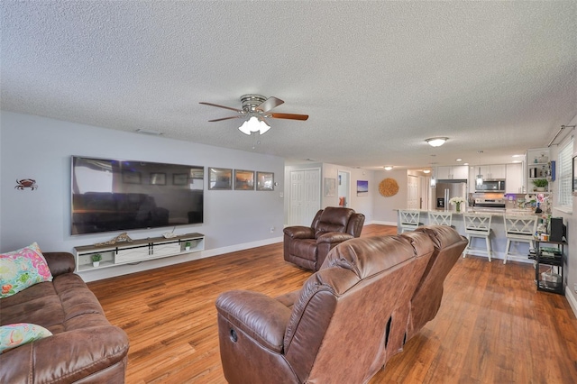 540 Firefly Ln, Apollo Beach, FL 33572 - living area with wood finished floors, ceiling fan, and a textured ceiling