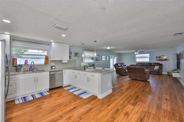 540 Firefly Ln, Apollo Beach, FL 33572 - kitchen featuring stainless steel appliances, a peninsula, light wood finished floors, open floor plan, and white cabinets