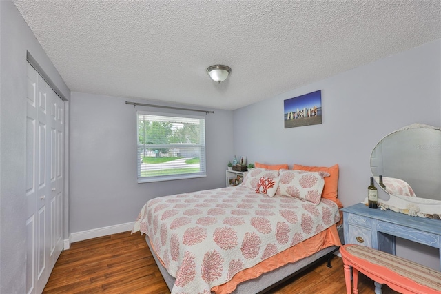 540 Firefly Ln, Apollo Beach, FL 33572 - bedroom with a closet, wood finished floors, and a textured ceiling