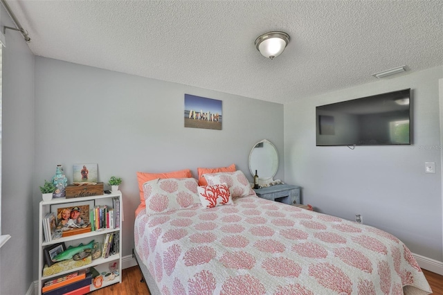 540 Firefly Ln, Apollo Beach, FL 33572 - bedroom featuring a textured ceiling and wood finished floors