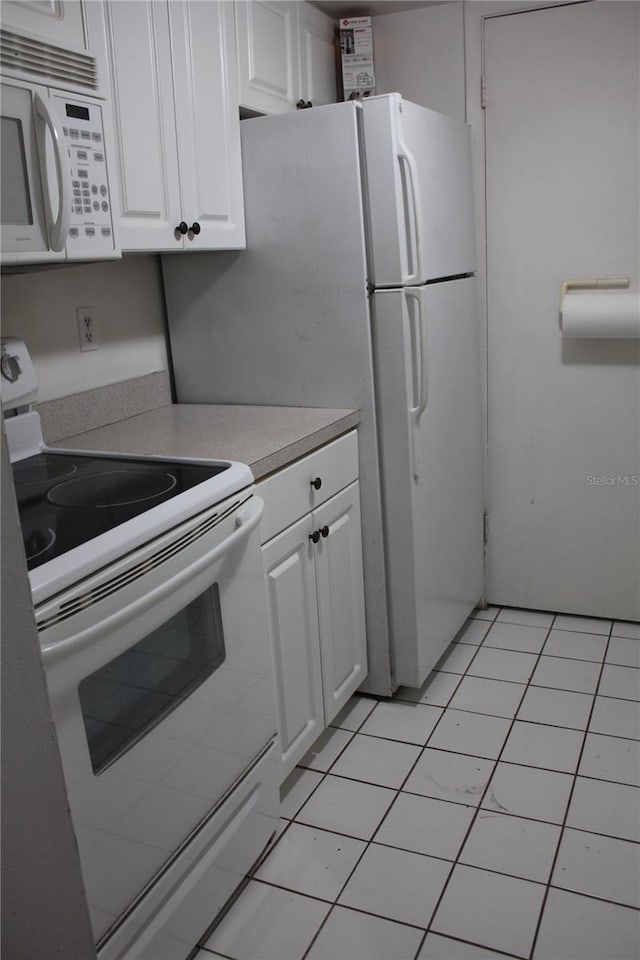 8220 12th Way N Unit H, Saint Petersburg, FL 33702 - kitchen featuring white appliances, white cabinets, light countertops, and light tile patterned flooring