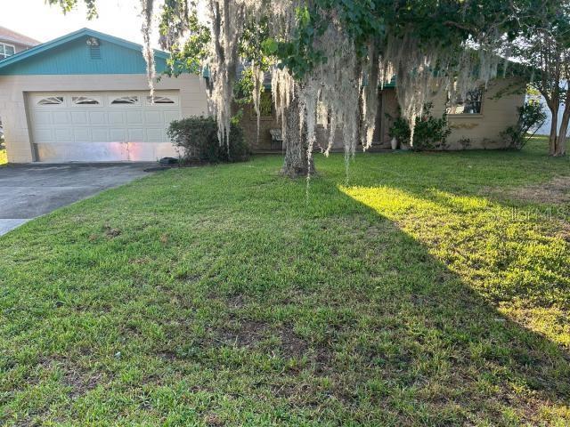3901 N Nokomis Pt, Crystal River, FL 34428 - view of green lawn with driveway and an attached garage