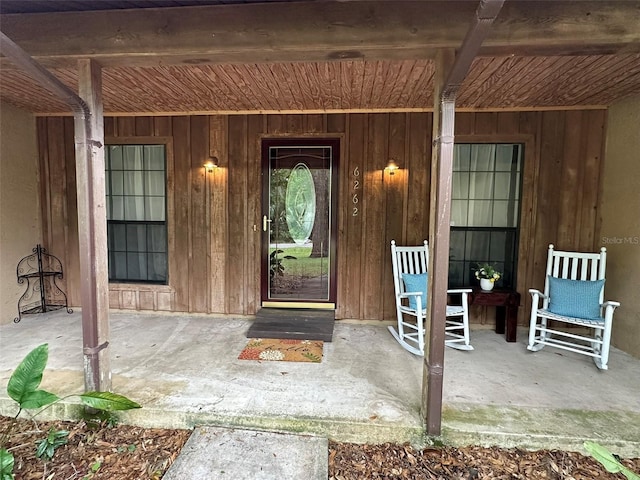 6262 E Rector St, Inverness, FL 34452 - doorway to property with covered porch and board and batten siding