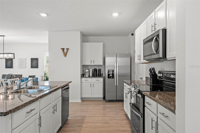 10823 Trailing Vine Dr, Tampa, FL 33610 - kitchen featuring stainless steel appliances, light wood finished floors, white cabinetry, a chandelier, and recessed lighting