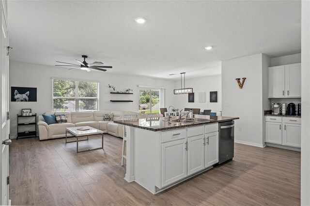 10823 Trailing Vine Dr, Tampa, FL 33610 - kitchen featuring dishwasher, light wood finished floors, white cabinets, an island with sink, and recessed lighting