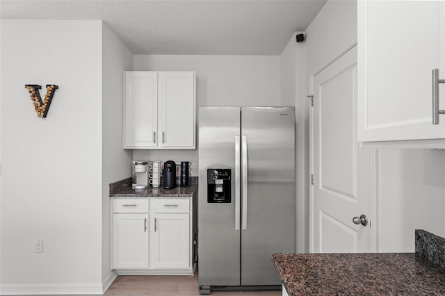 10823 Trailing Vine Dr, Tampa, FL 33610 - kitchen with stainless steel fridge with ice dispenser, dark stone counters, white cabinets, light wood finished floors, and a textured ceiling