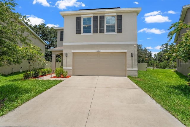 10823 Trailing Vine Dr, Tampa, FL 33610 - traditional-style home featuring stucco siding, an attached garage, concrete driveway, and a front lawn
