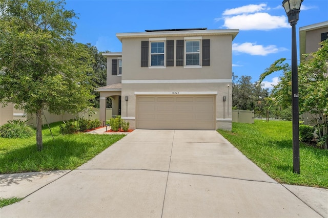 10823 Trailing Vine Dr, Tampa, FL 33610 - traditional home featuring stucco siding, driveway, a front yard, a garage, and solar panels
