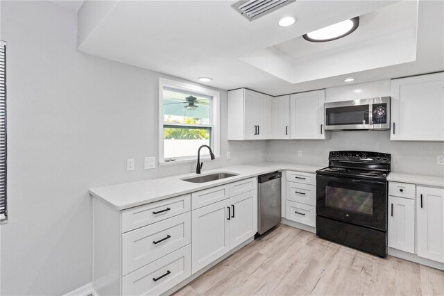 7322 Ellis Ln, Port Charlotte, FL 33981 - kitchen with stainless steel appliances, light wood-style flooring, light countertops, white cabinets, and recessed lighting