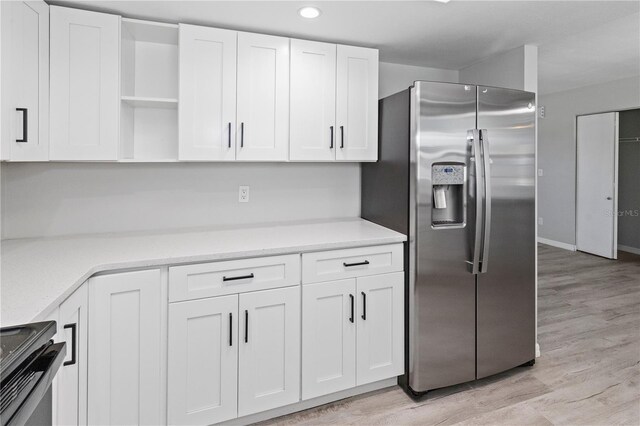 7322 Ellis Ln, Port Charlotte, FL 33981 - kitchen with stainless steel fridge, open shelves, stove, white cabinets, and recessed lighting