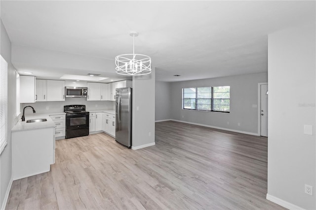 7322 Ellis Ln, Port Charlotte, FL 33981 - kitchen with appliances with stainless steel finishes, open floor plan, a chandelier, light countertops, and light wood finished floors