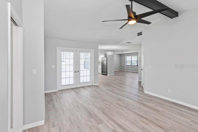 7322 Ellis Ln, Port Charlotte, FL 33981 - unfurnished living room featuring a ceiling fan, light wood-type flooring, french doors, and a chandelier
