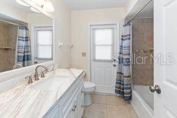 7322 Ellis Ln, Port Charlotte, FL 33981 - bathroom with tile patterned floors, vanity, and shower / bath combination with curtain