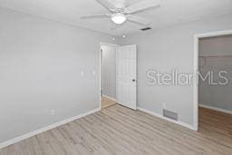 7322 Ellis Ln, Port Charlotte, FL 33981 - unfurnished bedroom featuring wood finished floors and a ceiling fan