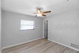 7322 Ellis Ln, Port Charlotte, FL 33981 - unfurnished room with wood finished floors and a ceiling fan