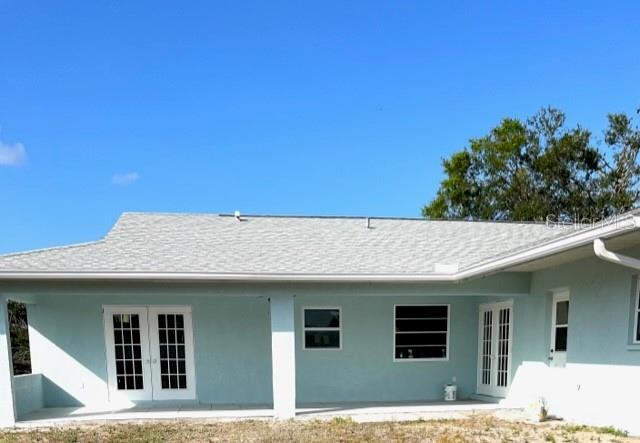 7322 Ellis Ln, Port Charlotte, FL 33981 - back of property with french doors, stucco siding, and a patio area