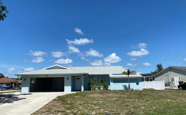 7322 Ellis Ln, Port Charlotte, FL 33981 - single story home with driveway, an attached garage, and a front lawn