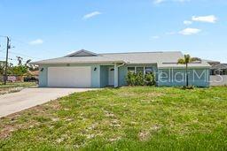 7322 Ellis Ln, Port Charlotte, FL 33981 - ranch-style home with a garage, concrete driveway, and a front yard