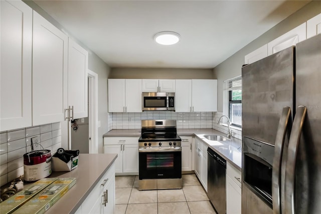 310 SW 76th Ter, North Lauderdale, FL 33068 - kitchen featuring stainless steel appliances, decorative backsplash, white cabinetry, and light tile patterned floors