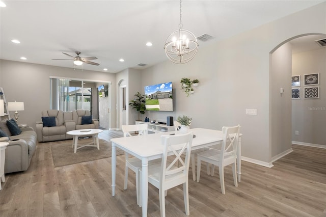 20108 Stone Pine Cir, Lutz, FL 33558 - dining area featuring arched walkways, light wood finished floors, recessed lighting, ceiling fan, and a chandelier
