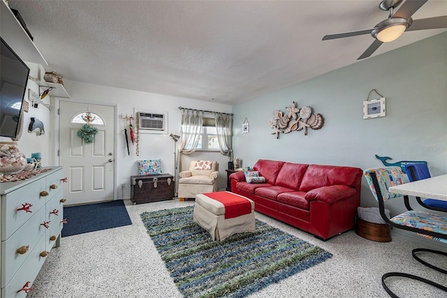 505 67th Ave Unit 11, St Pete Beach, FL 33706 - living room featuring speckle patterned floor, a wall mounted AC, a ceiling fan, and a textured ceiling