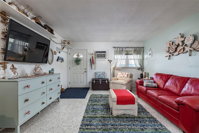 505 67th Ave Unit 11, St Pete Beach, FL 33706 - living area featuring a textured ceiling, a wall unit AC, and speckle patterned floor