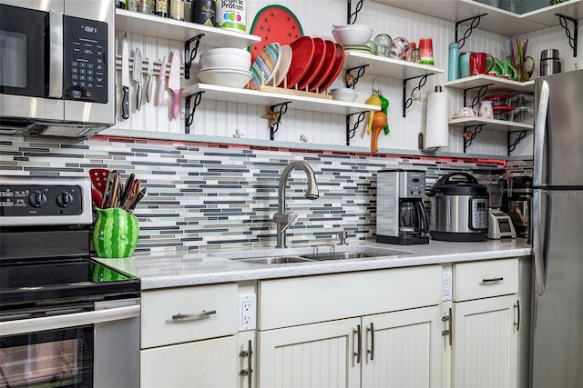 505 67th Ave Unit 11, St Pete Beach, FL 33706 - kitchen featuring stainless steel appliances, open shelves, decorative backsplash, white cabinets, and light stone countertops