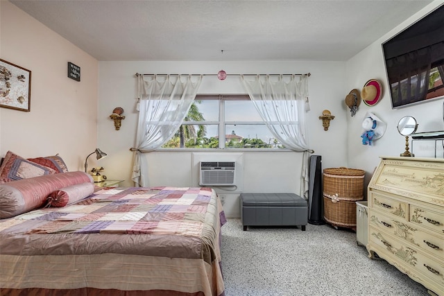 505 67th Ave Unit 11, St Pete Beach, FL 33706 - bedroom with a wall mounted AC and dark speckled floor