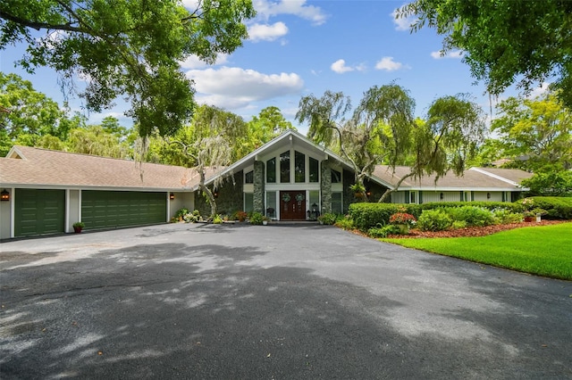 16205 Sentry Woods Ct, Odessa, FL 33556 - mid-century modern home featuring driveway, a garage, and stone siding