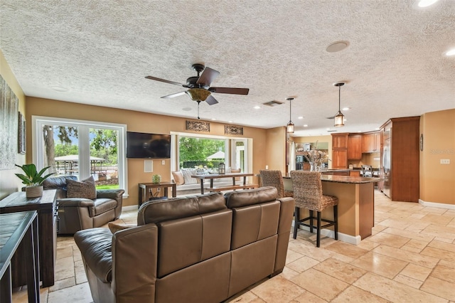 16205 Sentry Woods Ct, Odessa, FL 33556 - living area featuring a textured ceiling, ceiling fan, stone tile flooring, and recessed lighting