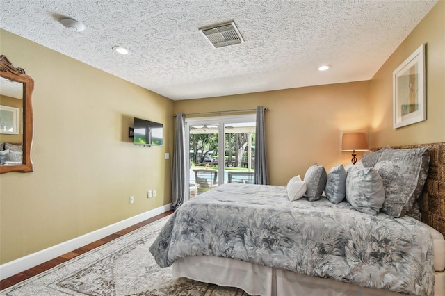 16205 Sentry Woods Ct, Odessa, FL 33556 - bedroom featuring access to exterior, a textured ceiling, wood finished floors, and recessed lighting