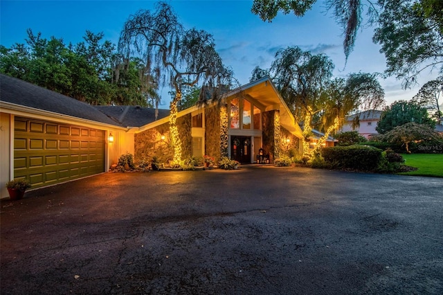 16205 Sentry Woods Ct, Odessa, FL 33556 - mid-century home featuring driveway, an attached garage, and stone siding