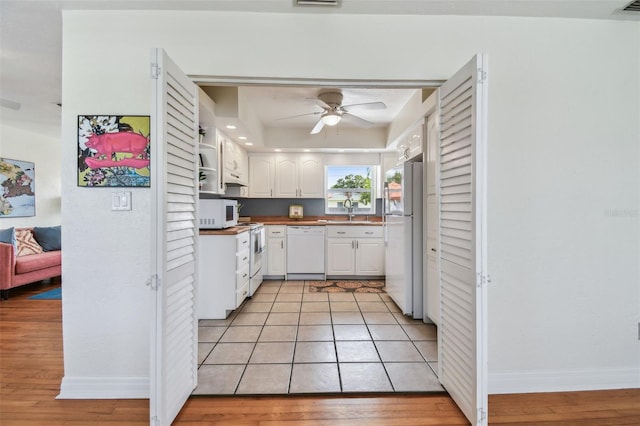 4211 28th Ave N, Saint Petersburg, FL 33713 - kitchen with white appliances, white cabinets, ceiling fan, and light wood-type flooring