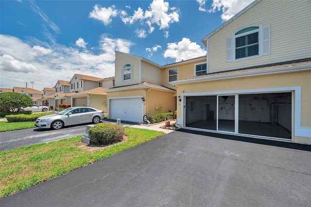 6400 46th Ave N Unit 61, Kenneth City, FL 33709 - view of front of property with asphalt driveway, a garage, stucco siding, and a residential view