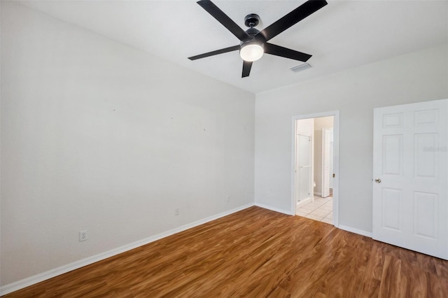 6400 46th Ave N Unit 61, Kenneth City, FL 33709 - unfurnished bedroom with wood finished floors, connected bathroom, and a ceiling fan