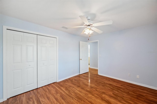 6400 46th Ave N Unit 61, Kenneth City, FL 33709 - unfurnished bedroom with wood finished floors, a closet, and a ceiling fan