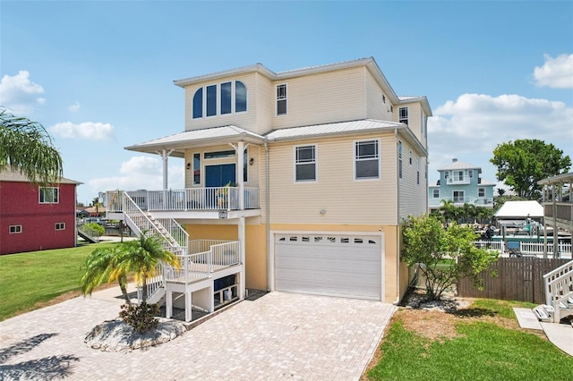 6543 Louise Ct, Hudson, FL 34667 - beach home with stairway, decorative driveway, an attached garage, and a porch