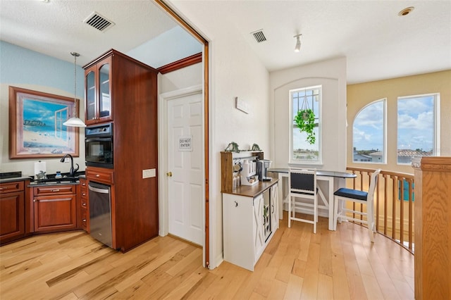 6543 Louise Ct, Hudson, FL 34667 - kitchen with dark countertops, light wood-style floors, and stainless steel dishwasher