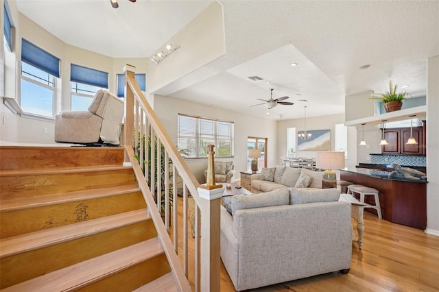 6543 Louise Ct, Hudson, FL 34667 - living room with light wood-type flooring, a ceiling fan, stairs, recessed lighting, and a chandelier