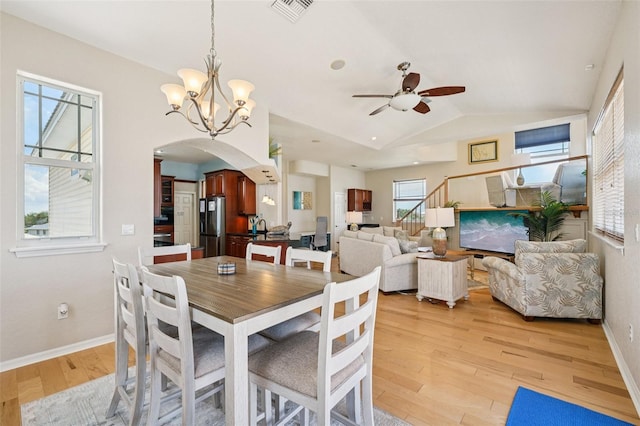 6543 Louise Ct, Hudson, FL 34667 - dining space with arched walkways, a ceiling fan, light wood-type flooring, a chandelier, and lofted ceiling