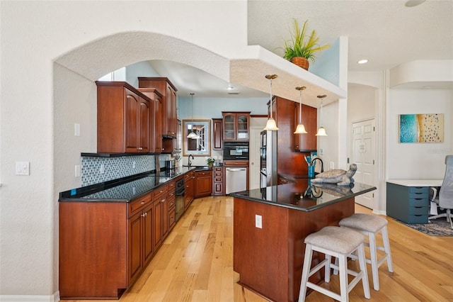 6543 Louise Ct, Hudson, FL 34667 - kitchen with a breakfast bar area, light wood-style flooring, dishwasher, dark countertops, and recessed lighting
