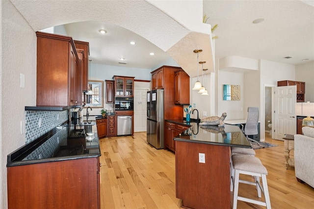 6543 Louise Ct, Hudson, FL 34667 - kitchen featuring appliances with stainless steel finishes, dark countertops, a peninsula, open floor plan, and light wood-style floors